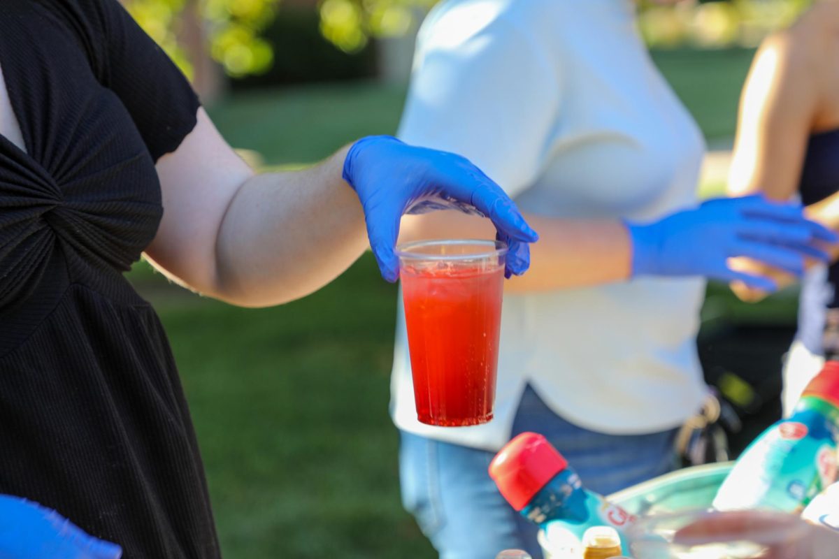 Junior Lauren Hughes serves a mocktail to a student. 