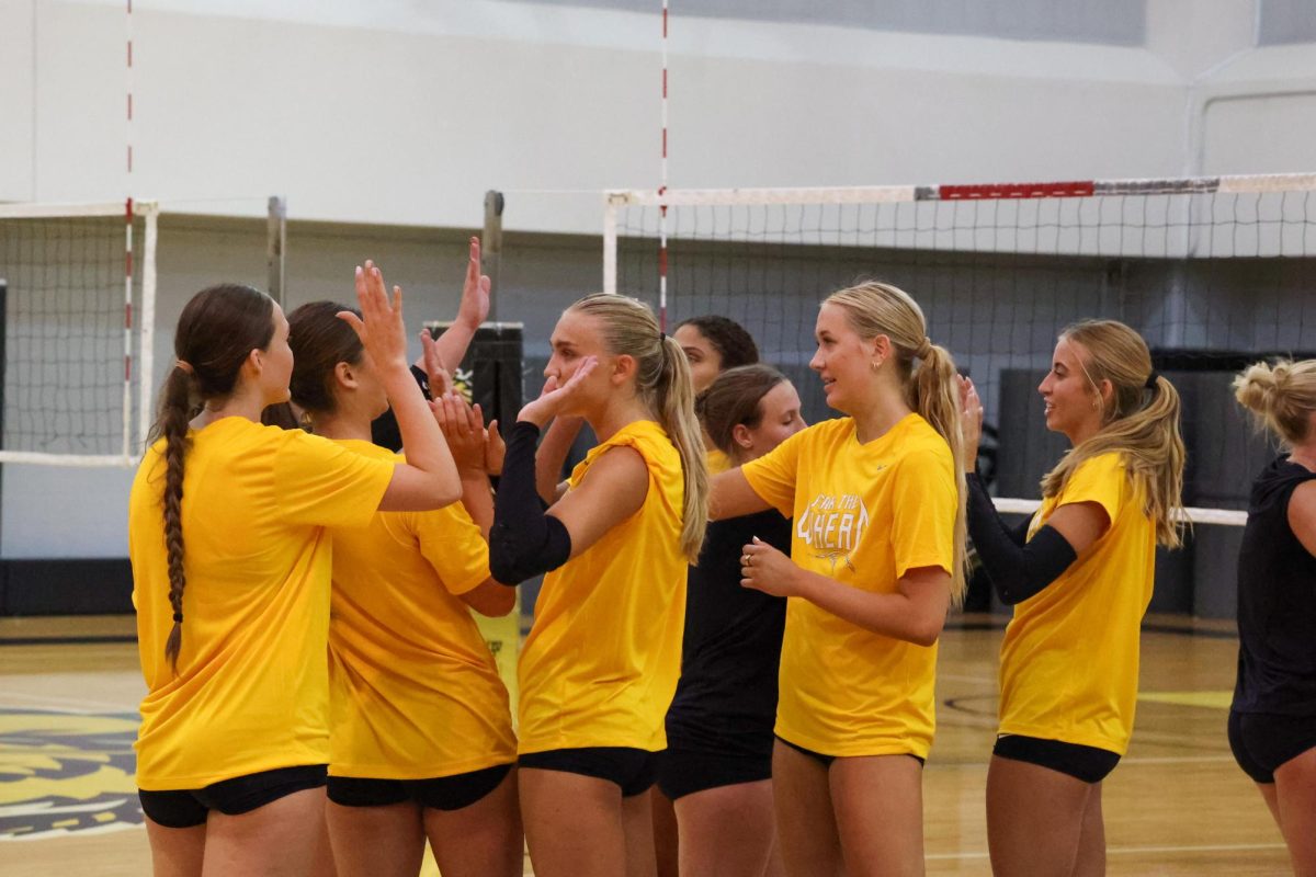 Wichita State volleyball players high-five after the completion of their first practice on Aug. 4. 