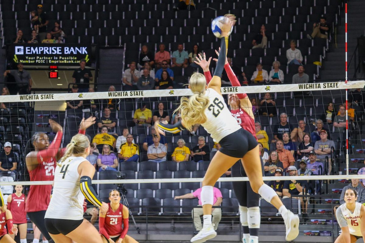 Sophomore middle blocker Allie Paulsen tries to spike the volleyball past an Arkansas player. Paulsen ended the game on Aug. 31 with four kills.