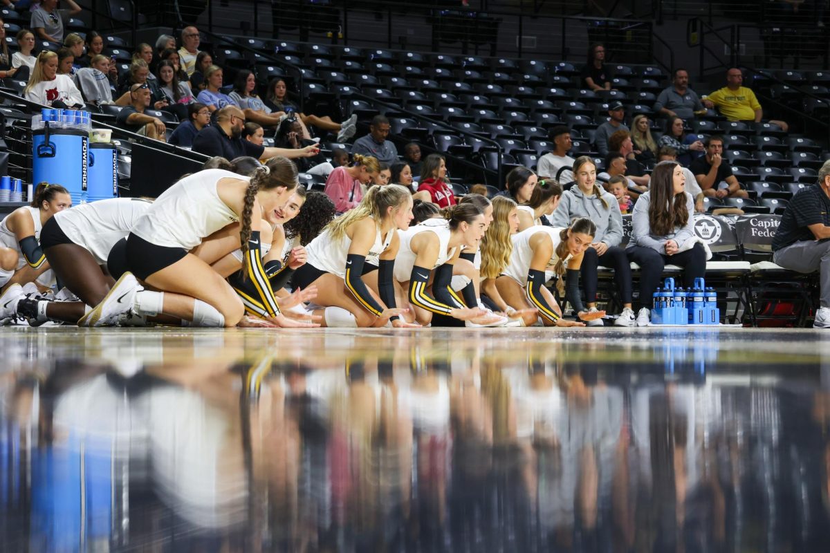 Wichita State's bench gets down on their knees and slaps the ground while Arkansas is serving. Arkansas ended with six service errors on Aug. 31.
