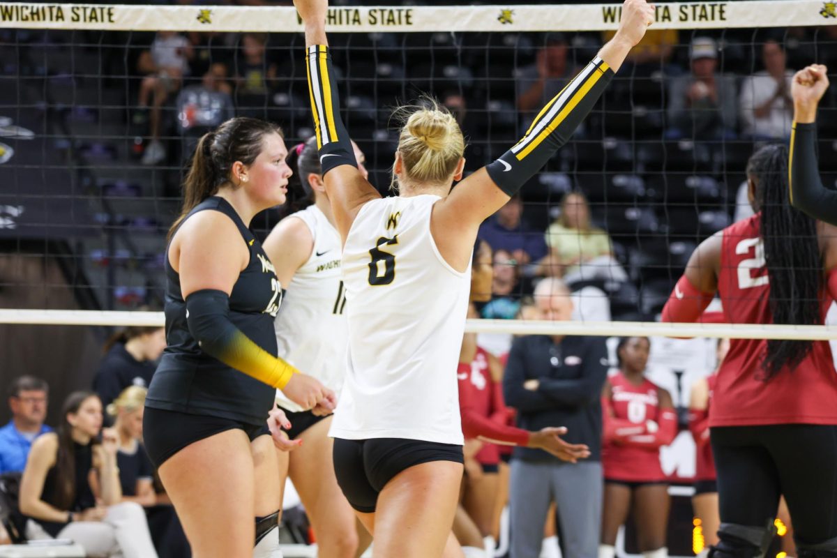Senior libero Katie Galligan puts her arms up after the Shockers score a point on Aug. 31. Galligan had 13 digs in the win over Arkansas.