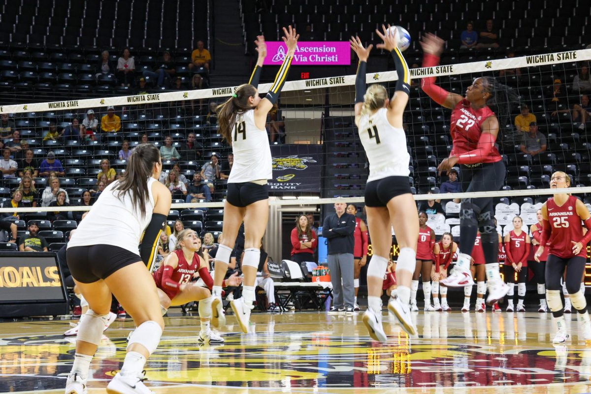Junior middle blocker Maddie Wilson and senior outside hitter Brooklyn Leggett go to block the ball on Aug. 31. The Shockers were out-blocked by the Razorbacks 11-9.
