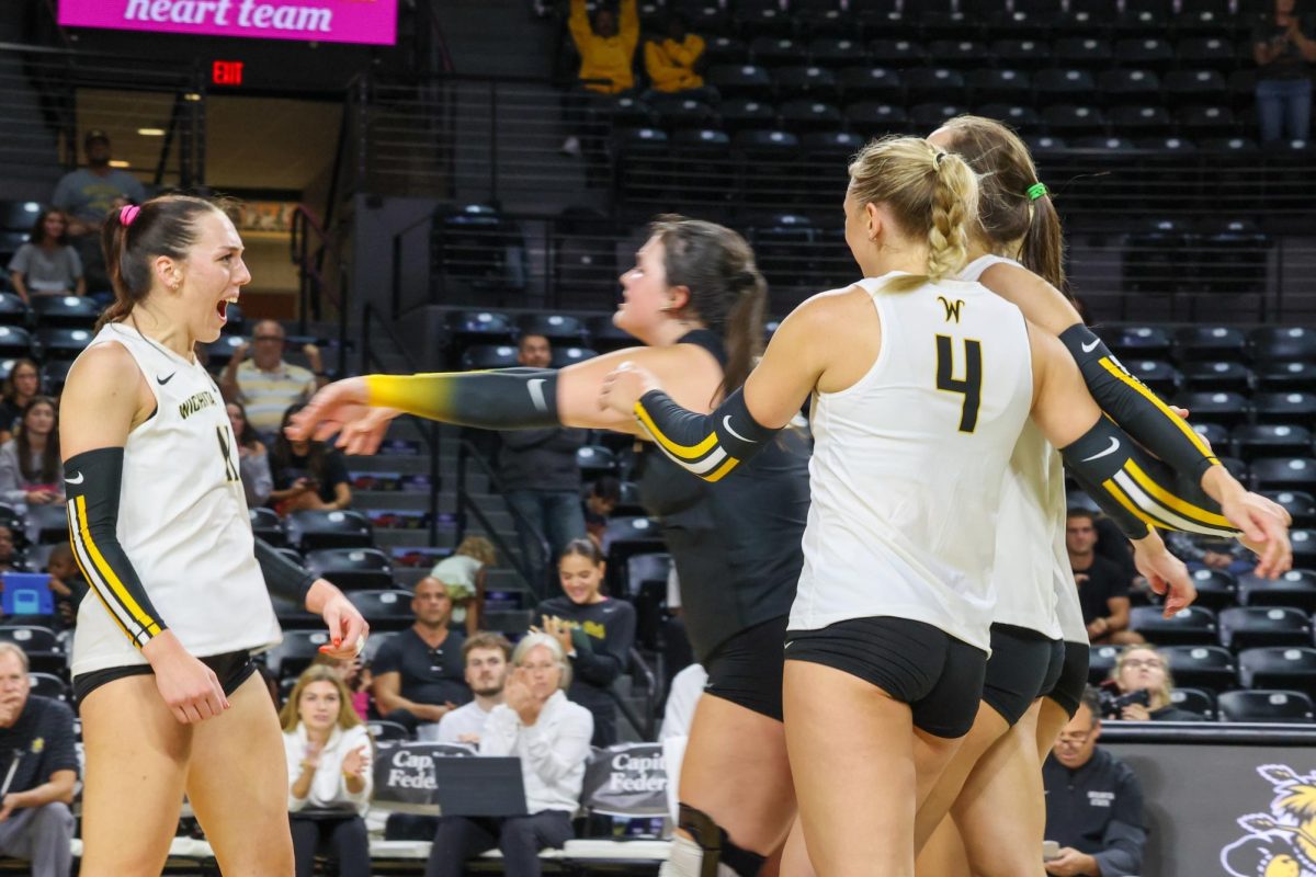 Junior libero Gabi Maas pushes junior outside hitter Sydney Dunning after a kill on Aug. 31. The Shockers ended the match against Arkansas with 64 kills.