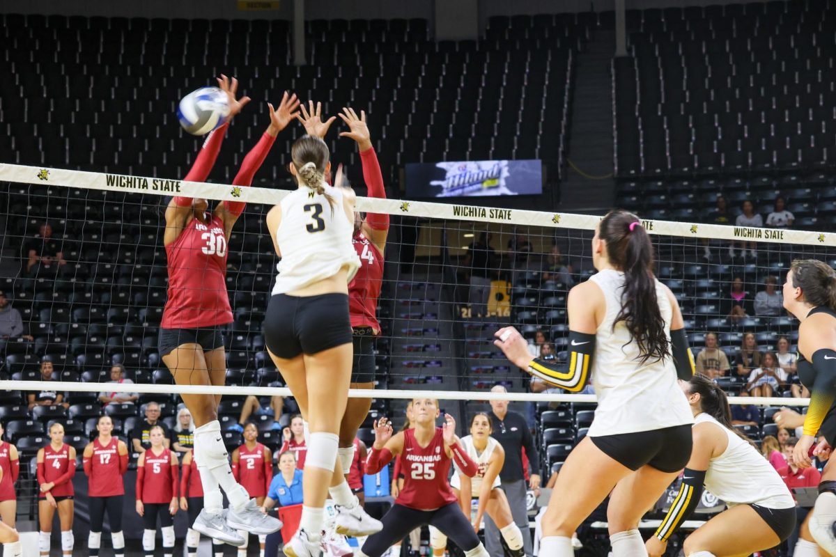 Freshman outside hitter Olivia Cohee spikes the ball against two Arkansas blockers. Cohee had a .286 kill percentage on the 3-2 win on Aug. 31.