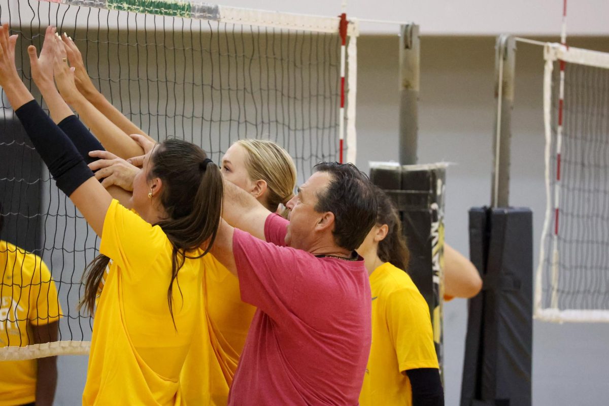 Wichita State head volleyball coach Chris Lamb adjusts where two players set their hands to go for a block. The Shockers made 275.5 blocks last season, good for the most in the conference.