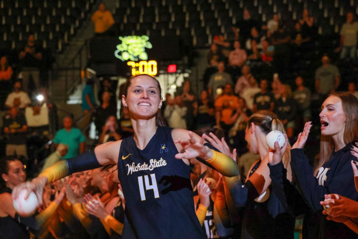 Junior middle blocker Maddie Wilson throws a ball into the crowd before the season-opener on Aug. 29. Wilson has played the last three years for the Shockers after transferring from Idaho.