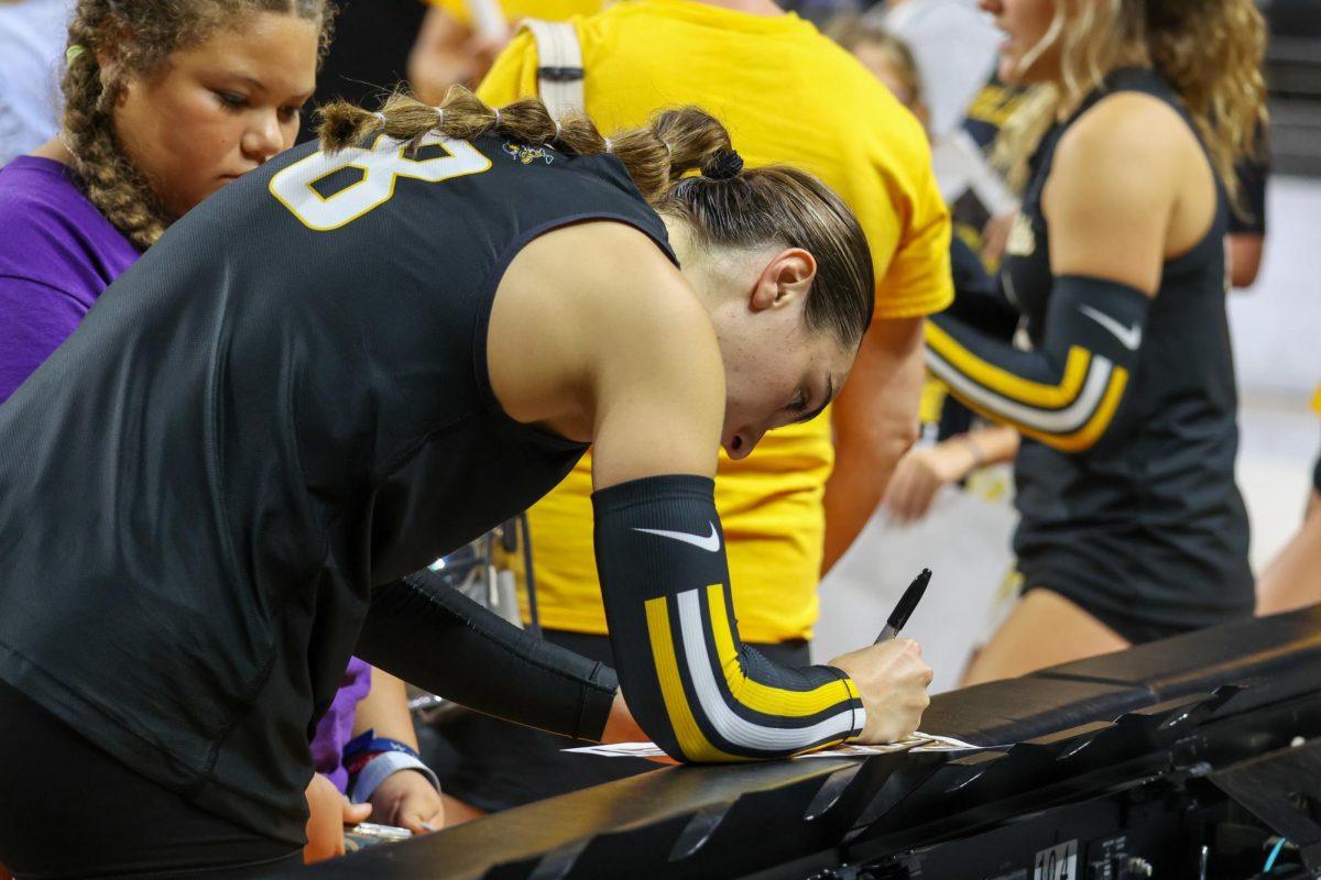 A kid watches as junior setter Hannah Hawkins signs an autograph for them after the Black and Yellow scrimmage on Aug. 23. Hawkins is a transfer from High Point in North Carolina.