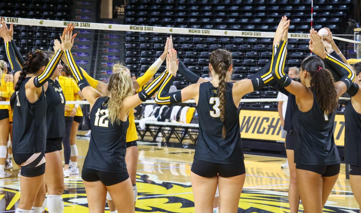 The Black team interlocks hands before the first set of WSU's Black and Yellow scrimmage. The Black team won the first set, 25-19.