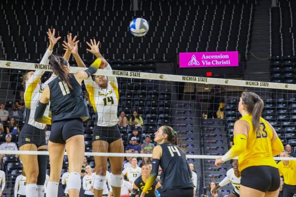 Junior outside hitter Sydney Dunning hits the ball past two Owls defenders on Aug. 29. Dunning ended the game against Kennesaw State with four kills.