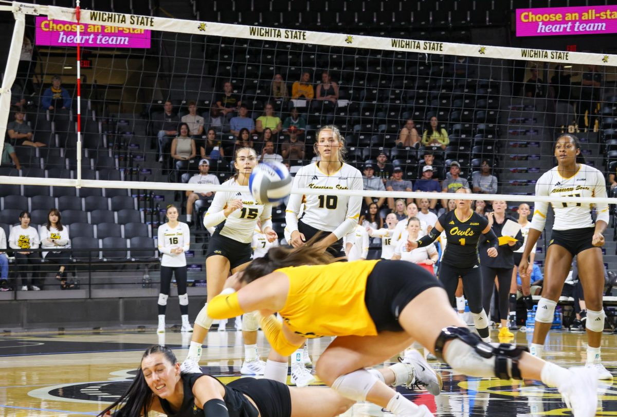 Junior libero Gabi Maas dives over fellow junior Sydney Dunning to save the ball. The Shockers lost to the Owls in straight sets on Aug. 29.