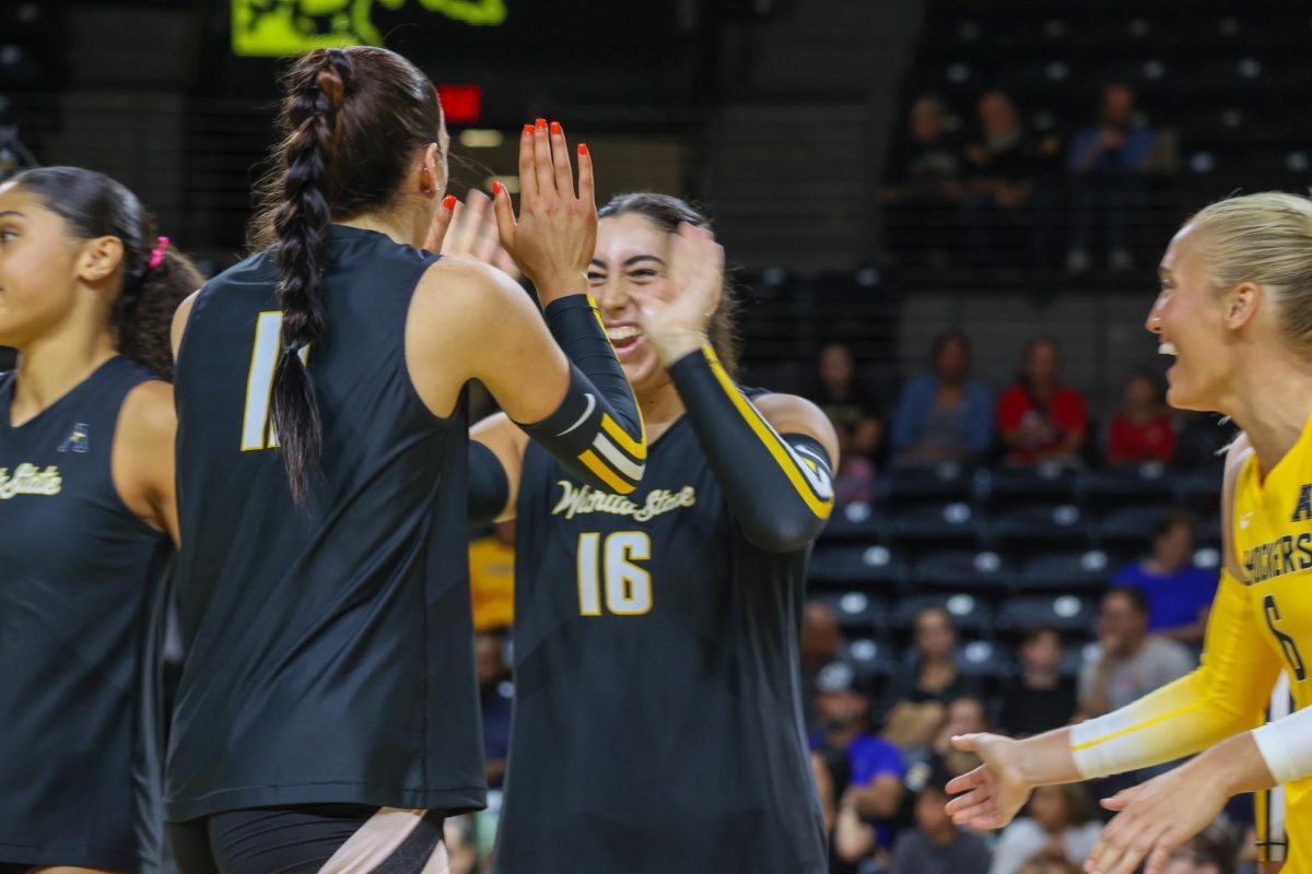 Juniors Sydney Dunning and Jordan Heatherly high-five after the Black team scored a point in the Black and Yellow scrimmage. Dunning and Heatherly both transferred to WSU over the offseason.