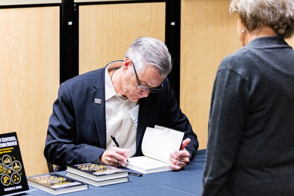 President Richard Muma signs Director of RSC Events Maria Ciski's copy of "Student Centered, Innovation Driven." Copies are available for purchase in the Shocker Store.