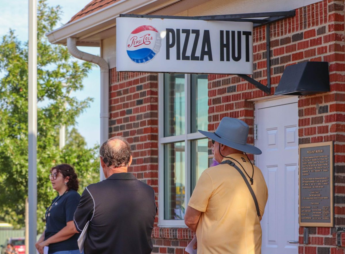 Attendees make a stop at the orignal Pizza Hut located on Wichita State's east campus. The walking tour also made stops at Cessna Stadium, Eck Stadium and the Corbin Education Center.