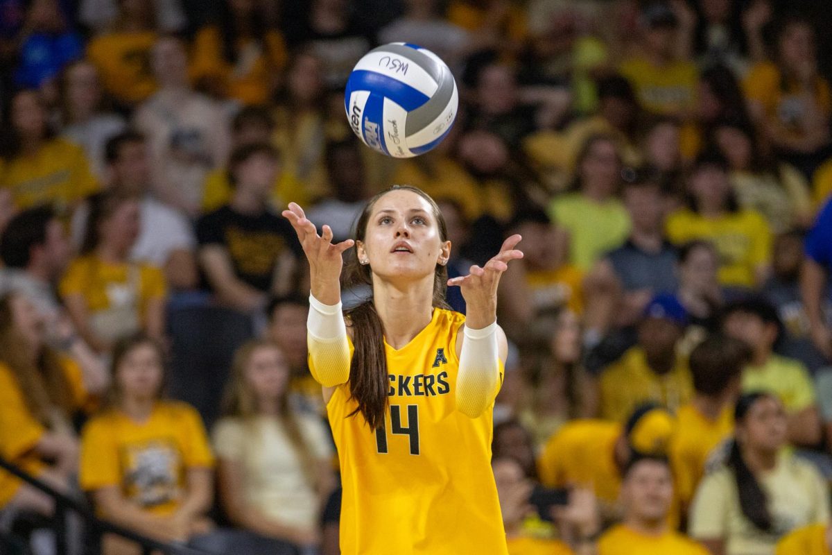 Middle blocker Maddie Wilson tosses the ball to serve against No. 17 Kansas on Sept. 16. The Shockers made three service aces in the 3-0 loss.