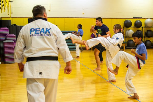 Members at a Peak ICT Martial Arts class practices high kicks on Sept. 4. The program is run by Samuel and Michelle Mayo.