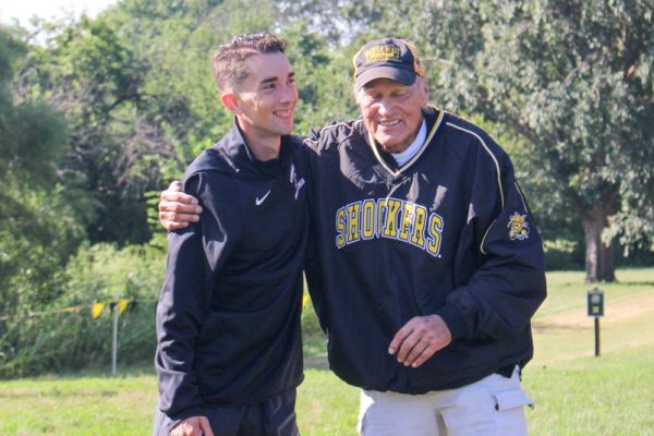 Senior Adrian Diaz Lopez hugs longtime Wichita State coach John Kornelson. Cross country’s home meet was renamed to honor Kornelson in 2001.