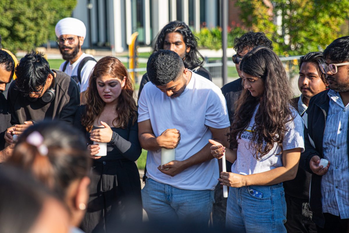 Students protect candles from the wind during a vigil on Sept. 9. The vigil was held in response to 22 protesters having been killed in Nepal in the week prior.