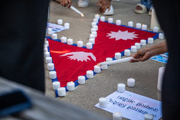 Students light candles around a Nepalese flag on Sept. 9. The vigil was organized by students the day prior.