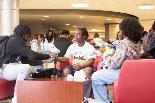 Sophomores Kourtney Walton, Terious Tellis and junior, Amir Muhammad sit around a table in the RSC showing off their stuffed bears. Student Activities Council gave out miniture shirts for the bears to wear at the event.
