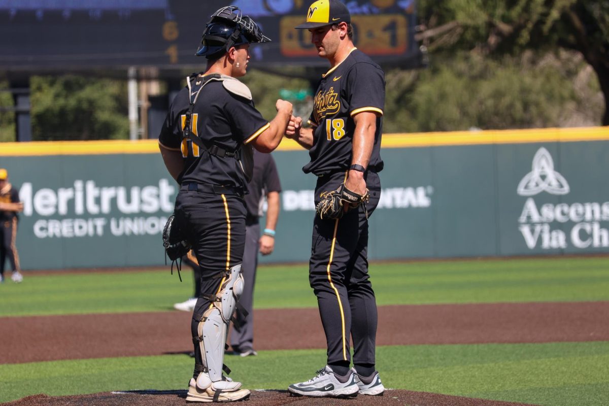 Senior catcher Max Kaufer (14) fist bumps junior pitcher Matthew Cuccias (18) on Saturday, Sept. 27, 2025, at Eck Stadium in Wichita, Kansas. Kaufer and Cuccias are both newcomers on the Wichita State baseball team.