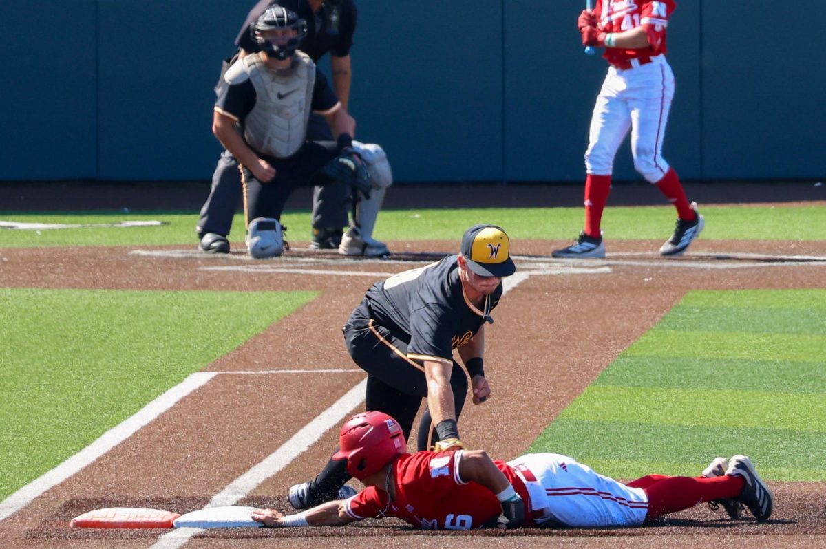 Junior Jack Quick (19) tries picking off a Nebraska runner during a game at Eck Stadium on Saturday, Sept. 27, 2025, in Wichita, Kansas. The runner was called safe on the play.