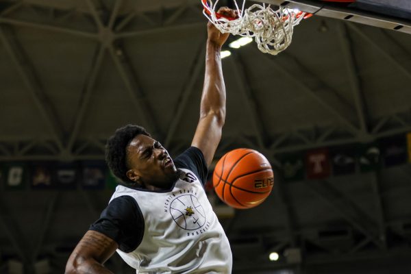 Forward Emmanuel Okorafor dunks the ball during a shoot around on Sept. 18. Okorafor, a senior, attended Louisville and Seton Hall before making his way to Wichita State.