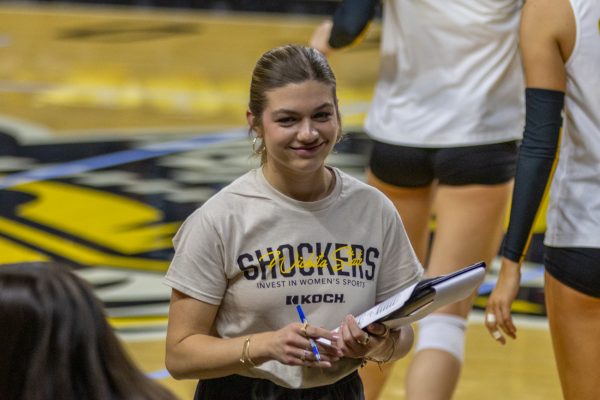 Wichita State volleyball graduate assistant coach Annalie Heliste smiles toward the Shockers' bench during a game against Tulane on Oct. 24. Heliste played libero for WSU from 2021-24.