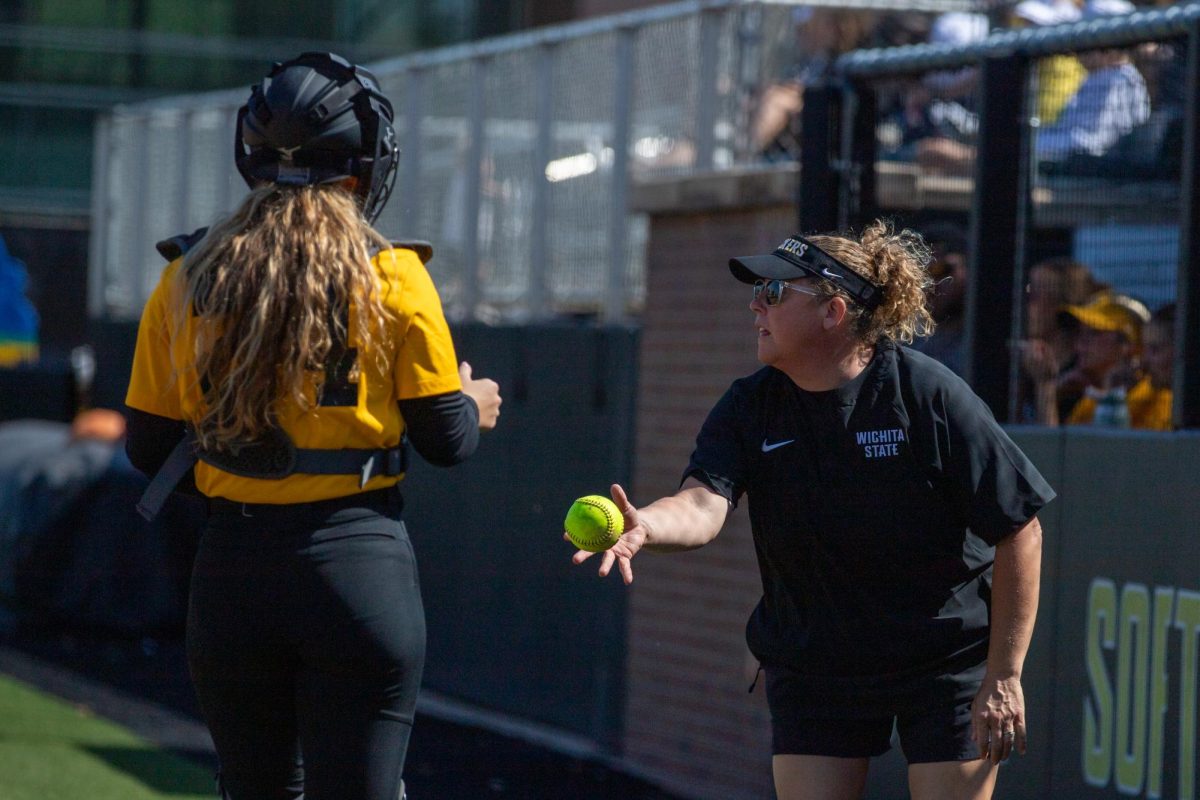 Wichita State softball coach Kristi Bredbenner tosses the ball to catcher Catelyn Beckerly (24) against McLennan Community College on Saturday, Oct. 4, 2025 at Wilkins Stadium. The Shockers won their fall schedule game, 14-1.
