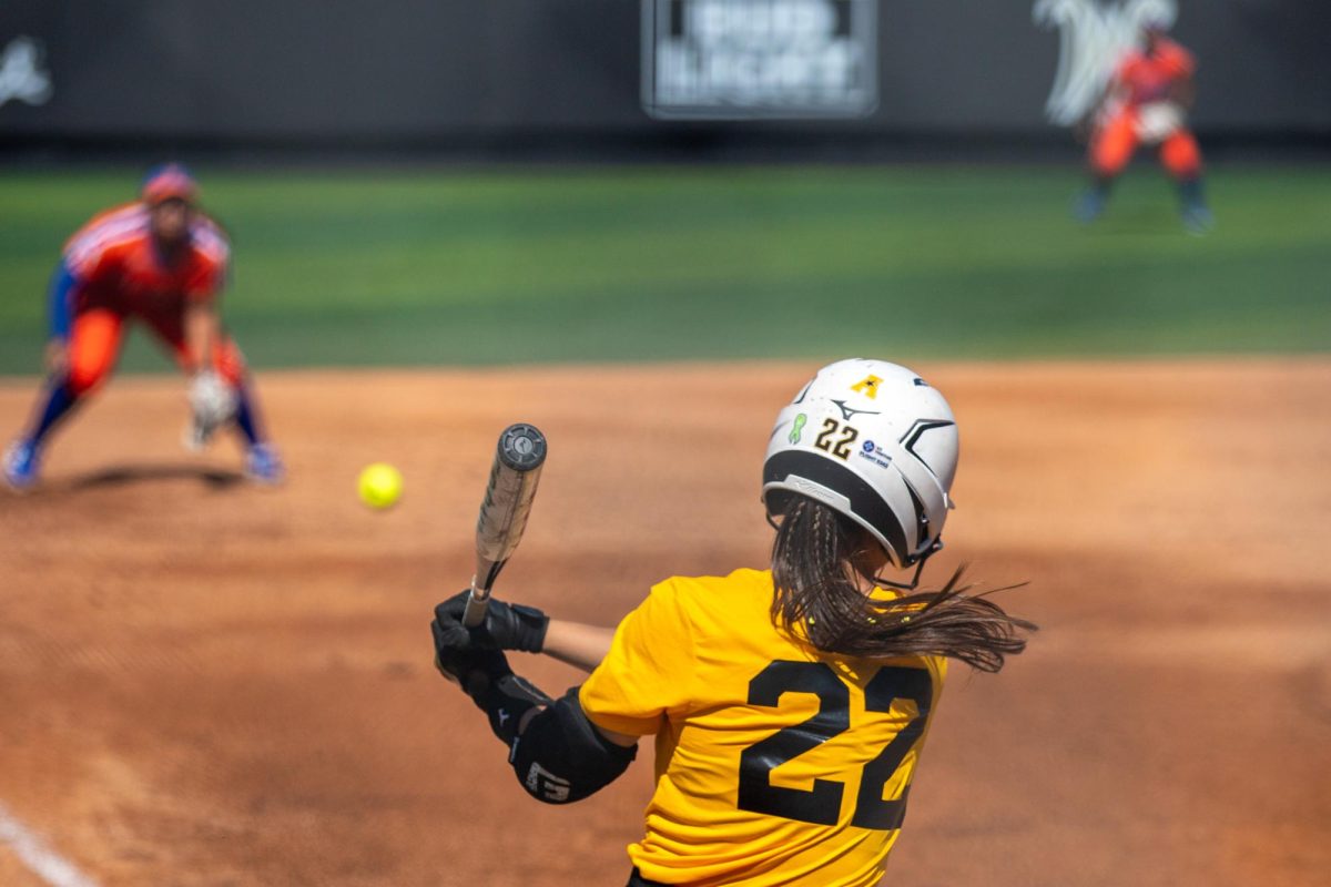 Wichita State softball senior Jodie Epperson (22) finishes her swing after making contact with a pitch against McLennan Community College on Saturday, Oct. 4, 2025, at Wilkins Stadium. The Shockers won, 14-1.
