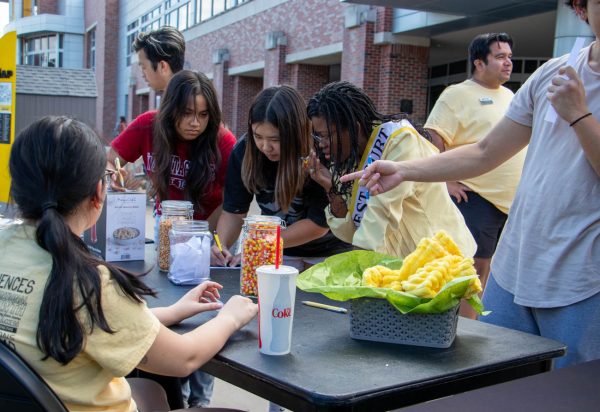 Students attempt to guess the number of candy corn or corn kernels in two jars during the Shocker Corn Roast. The event was organized by Student Engagement and Belonging.