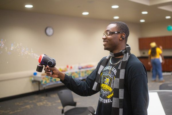 Sophomore Robert Hammond sprays bubbles on students trying to keep a balloon in the air. Hammond added multiple challenges until only one team's balloon was still floating.