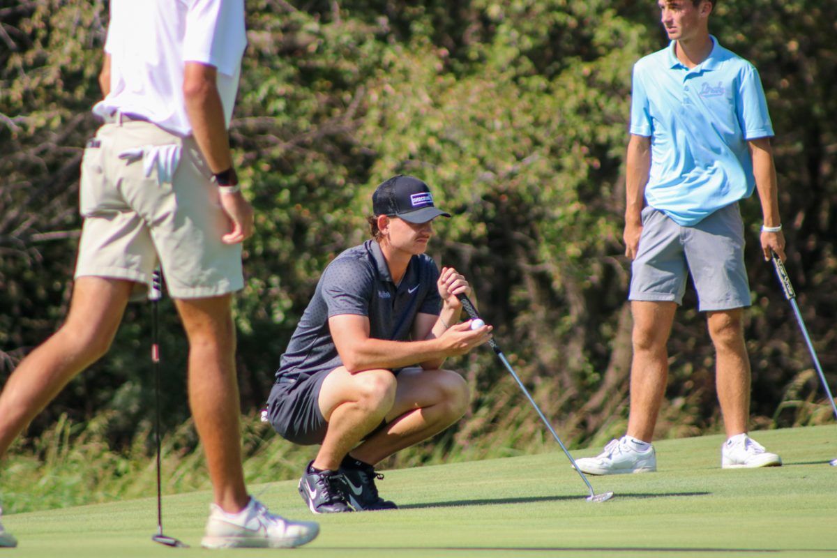Wichita State men's golf senior Mitchell Revie squats on the fringe to see his putting line at the Grier Jones Invitational on Sunday, Oct. 5, 2025, at the Sand Creek Station golf course in Newton, Kansas. Revie is Australia native in his second season at WSU.
