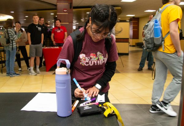 Maria Contreras uses a blue marker to color a bookmark. A make and take bookmark/book swap event was held in the RSC on Oct. 16.