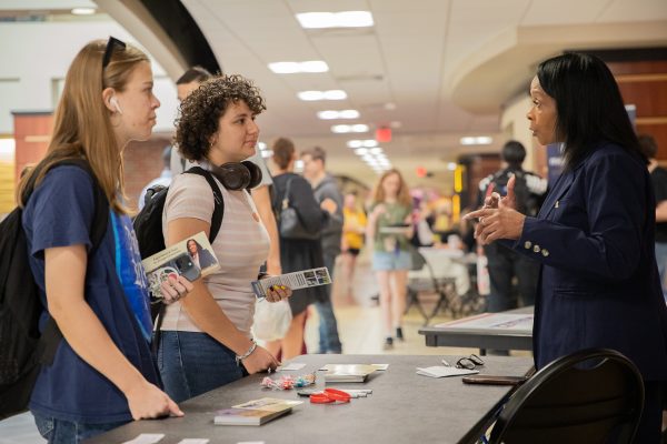 Students Azaria Pauls (left) and Adan Parker (middle) listen while Wichita City Council candidate LaWanda DeShazer talks about her campaign priorities. DeShazer and two other Wichita City Council candidates attended the meet and greet hosted by Shockers Vote. 