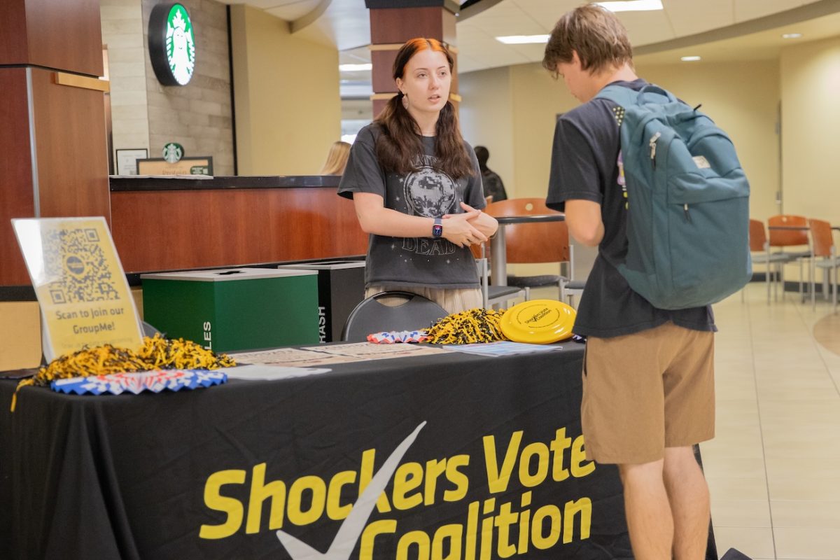 Shockers Vote Campus Coalition President Amelia Locke tells Carson Blasdel about the group at their candidate meet and greet event on Oct. 15. Shockers Vote aims to engage students with civics and encourage voting.
