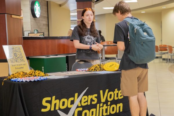 Shockers Vote Campus Coalition President Amelia Locke tells Carson Blasdel about the group at their candidate meet and greet event on Oct. 15. Shockers Vote aims to engage students with civics and encourage voting.
