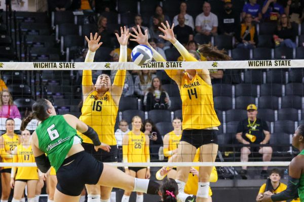 Wichita State volleyball junior middle blocker Maddie Wilson (14) and junior setter Jordan Heatherly (16) block the ball from going over the net against North Texas on Oct. 26. Wilson and Heatherly combined for 11 blocks during the 3-2 loss.
