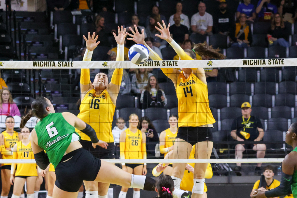 Wichita State volleyball junior middle blocker Maddie Wilson (14) and junior setter Jordan Heatherly (16) block the ball from going over the net against North Texas on Oct. 26. Wilson and Heatherly combined for 11 blocks during the 3-2 loss.