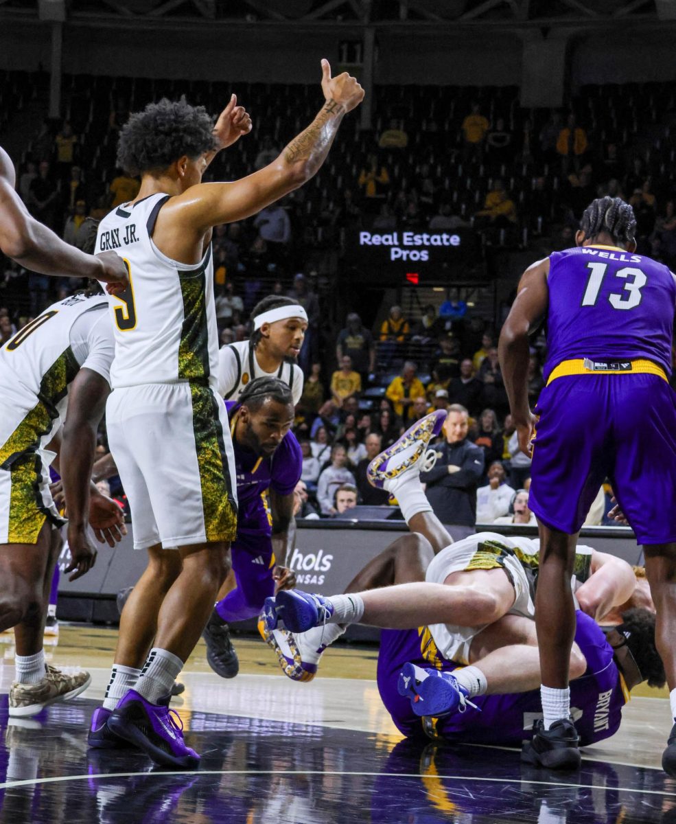 Wichita State senior Mike Gray Jr. (9) signals for a jump ball as Will Berg (44) and a Prairie View A&M player fight for possession on Nov. 8. The Shockers won, 105-62.