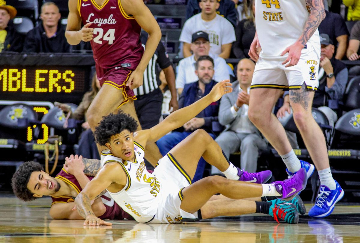 Wichita State men's basketball guard Mike Gray Jr. (9) gets off the court after scrapping for a loose ball against Loyola-Chicago on Nov. 13. Gray scored 17 points in the 95-74 win.