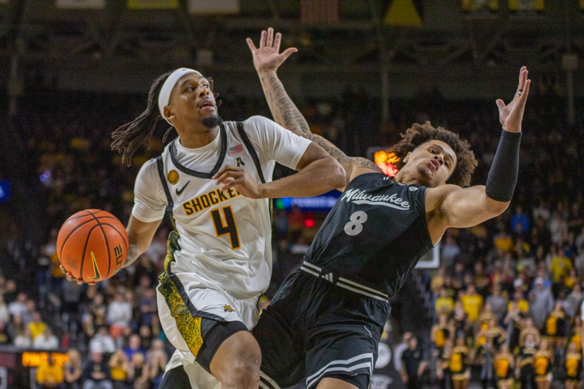 Wichita State men's basketball redshirt freshman guard TJ Williams makes contact with a Milwaukee defender in the second half on Nov. 22. Williams is an alum of Wichita Heights High School.