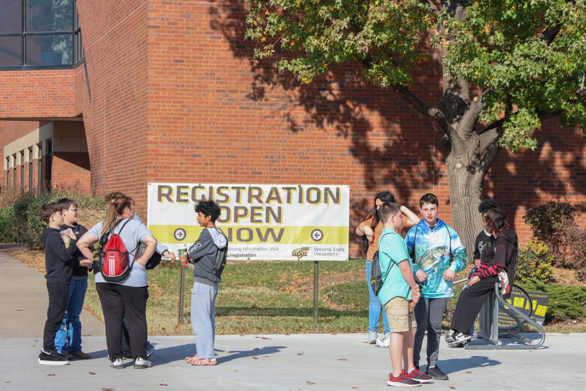 Students visiting Wichita State stand and talk near Elliott Hall on Sept. 17.