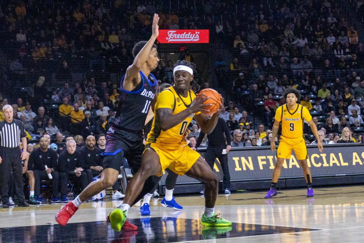 Wichita State men's basketball senior forward Karon Boyd (0) backs down DePaul's senior guard CJ Gunn (11) in the first half on Dec. 13. The Shockers lost, 61-58.
