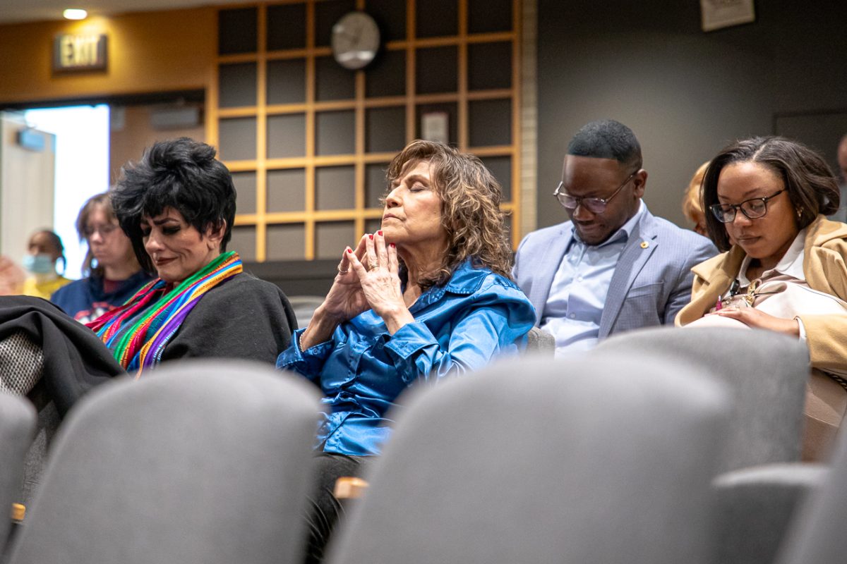 A member of the audience prays for the lives lost on flight 5342 on Jan. 29.