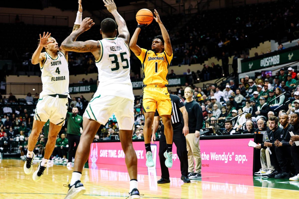 Wichita State men's basketball senior guard Kenyon Giles (1) shoots a 3-pointer over two South Florida defenders on Jan. 18 inside the Yuengling Center. Giles scored 22 points in the Shockers' 86-85 overtime win. (Photo courtesy of Wichita State Athletics)