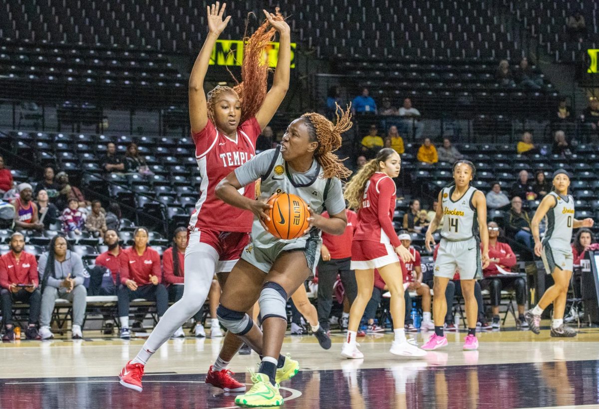 Wichita State women's basketball senior forward Maimouna Sissoko (24) attempts to drive past a Temple defender on Jan. 6. The Shockers lost 70-50.