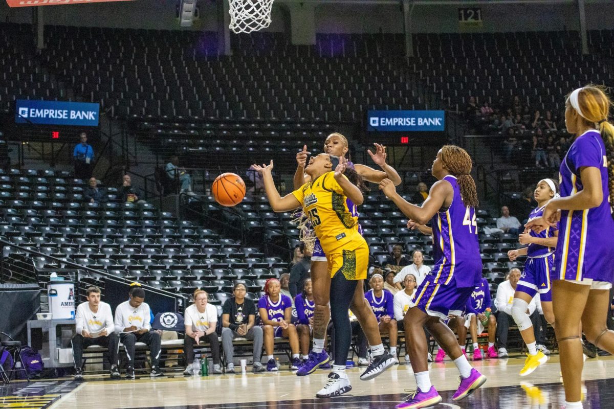 Wichita State women's basketball junior guard Karys Washington (25) gets fouled by an East Carolina Pirate on Jan. 10. The Shockers lost, 83-56.