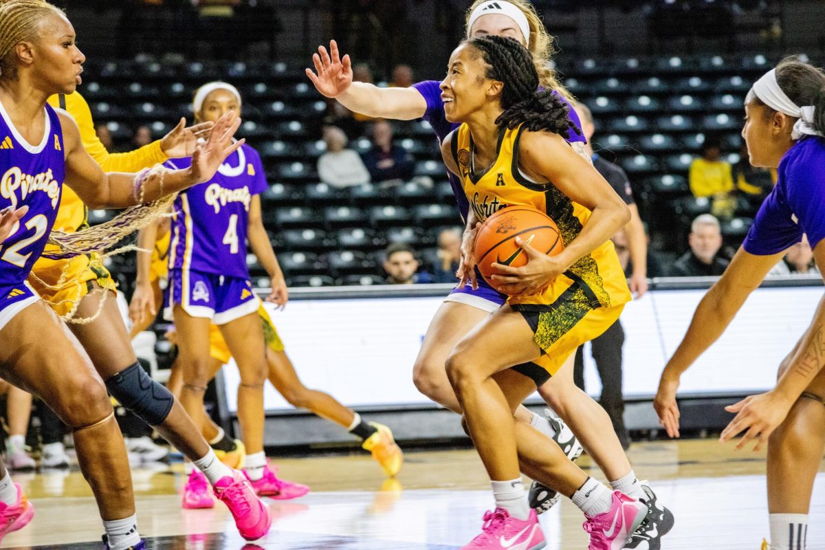 Wichita State women's basketball graduate guard Taya Davis (14) fights past East Carolina's defense on Jan. 10. The Shockers turned the ball over 27 times in the 83-56 loss.