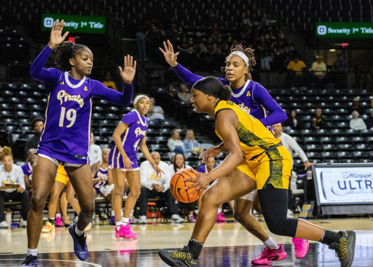 Wichita State women's basketball graduate forward Bre'Yon White (12) drives past two East Carolina defenders on Jan. 10. White ended the game with six points and five rebounds.
