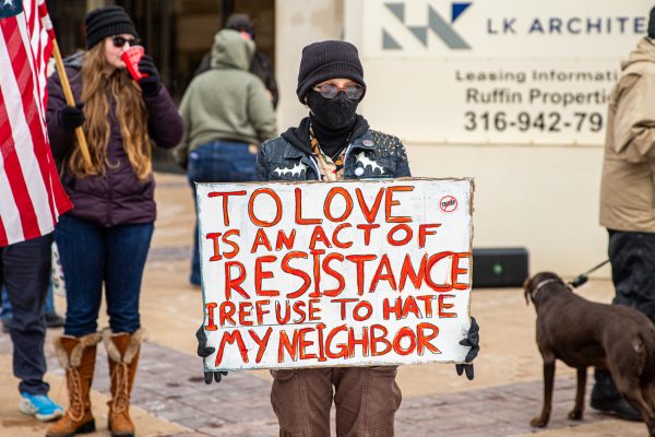 A student holds a protest sign on a street corner on Jan. 31. Both community members and university students came out to the protest.